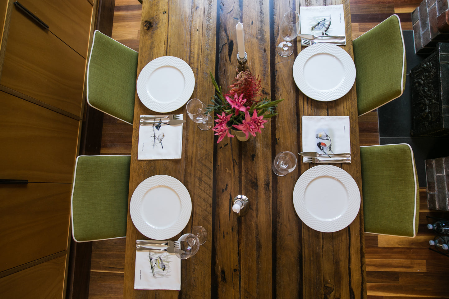 Aerial shot of a dining setting with cloth napkins and serviettes featuring Australian bird life